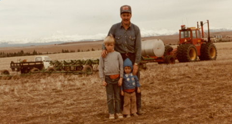 Two kids and man in field